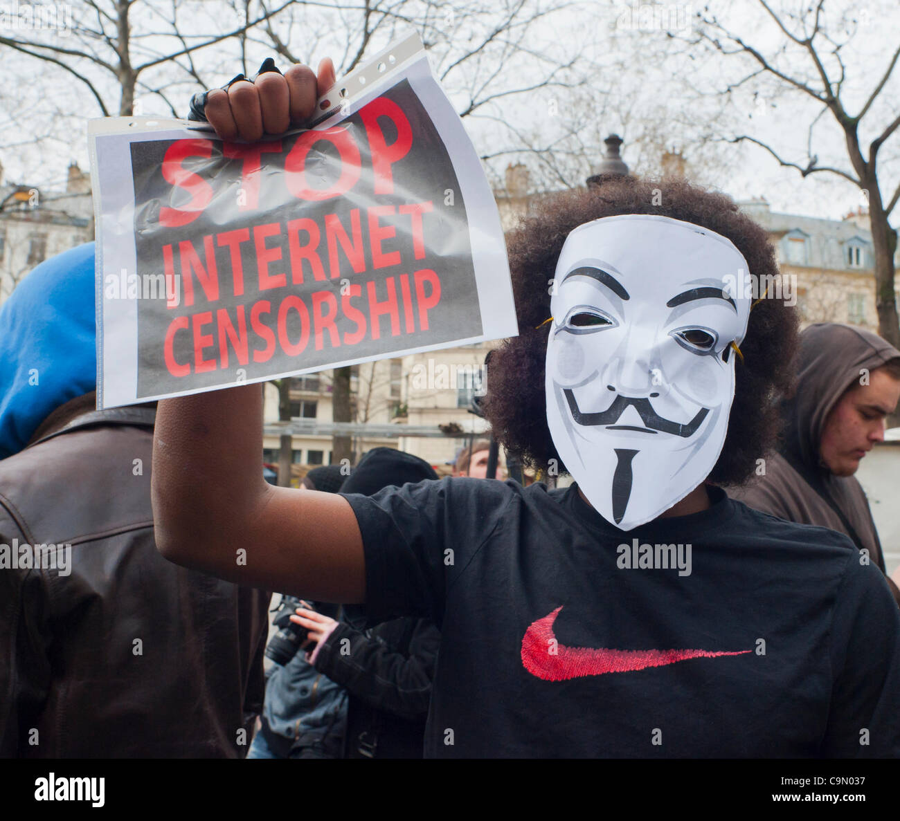 Anonymer Protest gegen Internet Anti-Piraterie-Gesetz, ACTA (Anti-Counterfeiting Trade Agreement), das die Freiheit des Internets bedroht, Paris, Frankreich, Französisch Teen Holding Protestschild auf der Straße, Mann versteckt Gesicht Stockfoto