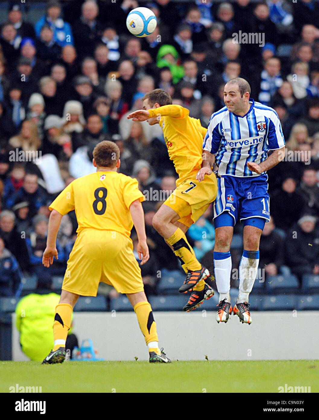 Glasgow, Vereinigtes Königreich. 28.01.12.  Hampden Park schottischen Gemeinden League Cup-Halbfinale.  Ayr United V Kilmarnock leitet zuerst. Kilmarnock Mittelfeldspieler Gary Harkins kommt heraus auf die Oberseite mit dieser Antenne Herausforderung gegen Ayr United Alan Trouten (gelben Streifen) in der zweiten Hälfte des Spiels. Stockfoto