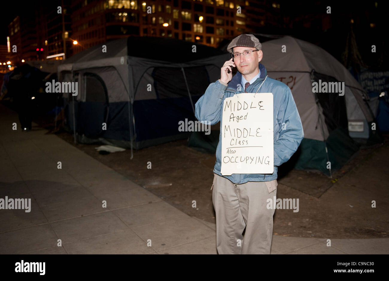 Januar hatte 30,2012, McPherson Square, Occupy Washington DC, ein Mann, ein Zeichen, das ' im Alter von Mitte Mittelschicht auch besetzen ' in der Nacht die Stadt liest die Besatzer gesagt, kein schlafen oder auf dem Campingplatz im park Stockfoto