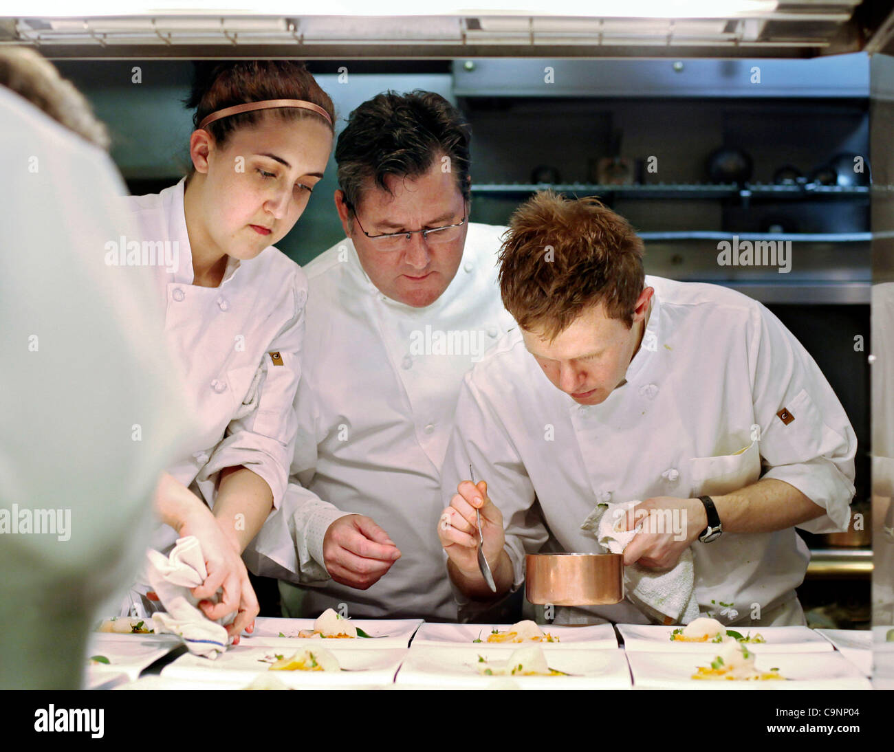 24. März 2011 - Chicago, Illinois, USA - Chef Charlie Trotter, Besitzer von  Charlie Trotter, Center, arbeitet mit Koch Lindsey Clemage und Sous Chef  Mitchell Nordby, wie sie Geschirr Teller. Trotter eröffnet