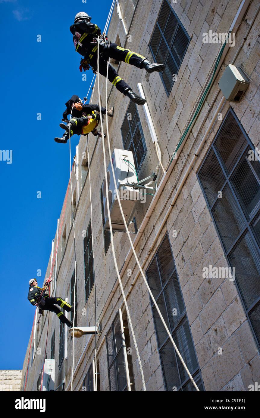 Feuerwehr Abseilen vom Dach der Schule bei den Rettungsarbeiten nach einem Erdbeben in einer landesweiten Übung Simulation an der Bet-Hakerem Grundschule. Jerusalem, Israel. 20. Februar 2012. Stockfoto