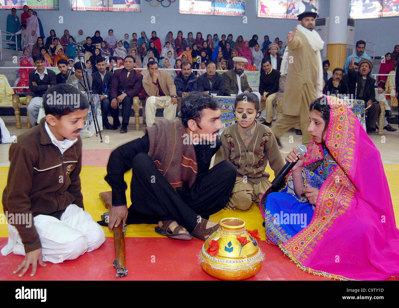 Schüler tragen traditionelle Kleider, die vorliegenden Tableau während Sport Gala statt Gandhara Universität in Peshawar auf Dienstag, 21. Februar 2012. Stockfoto