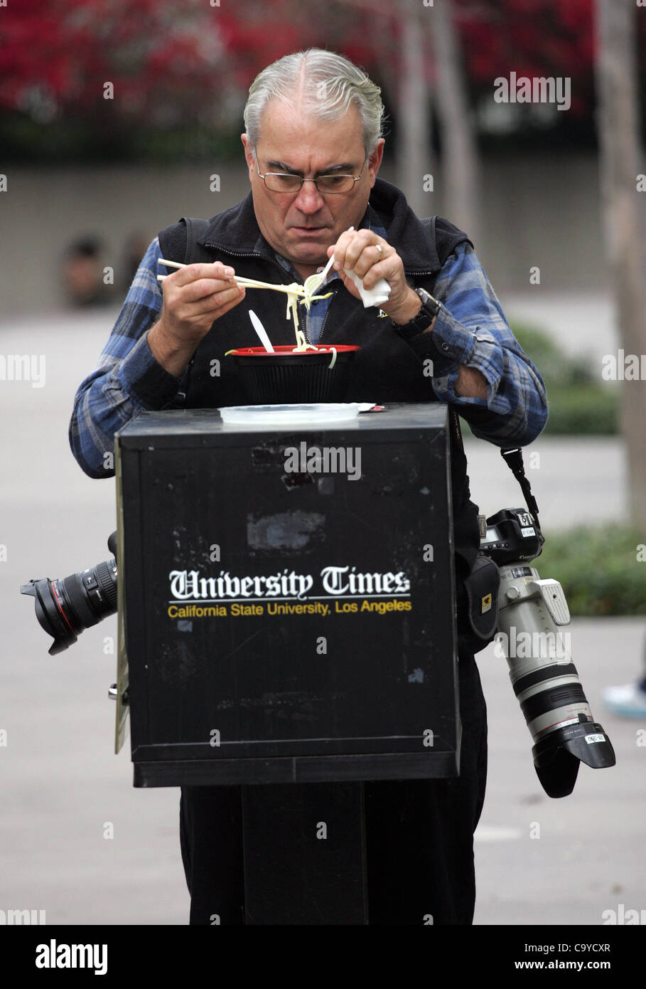 6. März 2012 - Los Angeles, Kalifornien, USA - AP Fotografen REED SAXON genießt sein Mittagessen während des Wartens auf einen Protest auf dem Campus der California State University von Los Angeles in Kalifornien, wo eine Demonstration abgehalten wurde, um SCULAs und andere California Universitäten fehlende Unterstützung bis Ende t protestieren Stockfoto