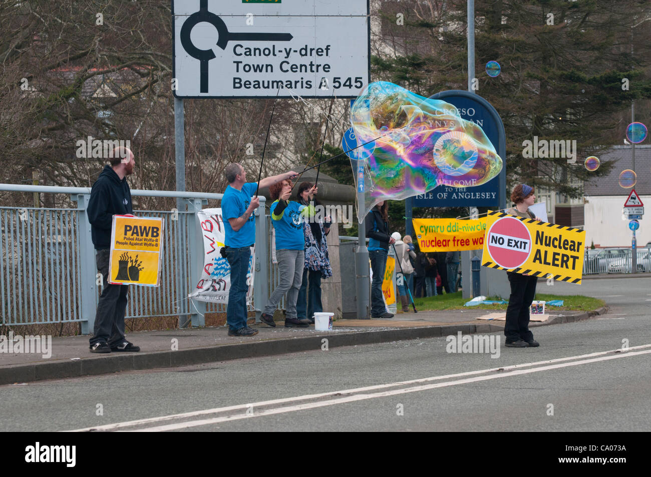 Menschen gegen das geplante Kernkraftwerk Wylfa B protest von Menai Hängebrücke Anglesey am 11. März 2012 den ersten Jahrestag der Katastrophe von Fukushima mit Unterstützung der CND Cymru walisischen Sprache Gesellschaft Greenpeace und Bangor und Ynys Mon Friedensgruppe Stockfoto