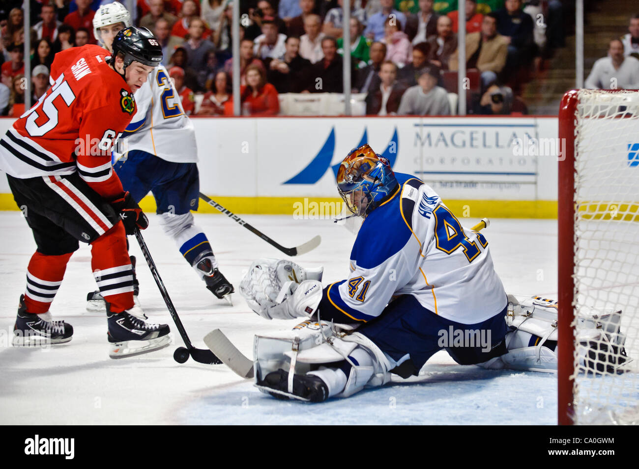 13. März 2012 - blockt Chicago, Illinois, USA - St. Louis Goalie Jaroslav Halak (41) den Schuß auf einen Schuss, während Chicago Center Andrew Shaw (65) sieht um die Erholung während des NHL-Spiels zwischen den Chicago Blackhawks und den St. Louis Blues im United Center in Chicago, IL zu sammeln. Die Blackhawks allsiegenden Stockfoto