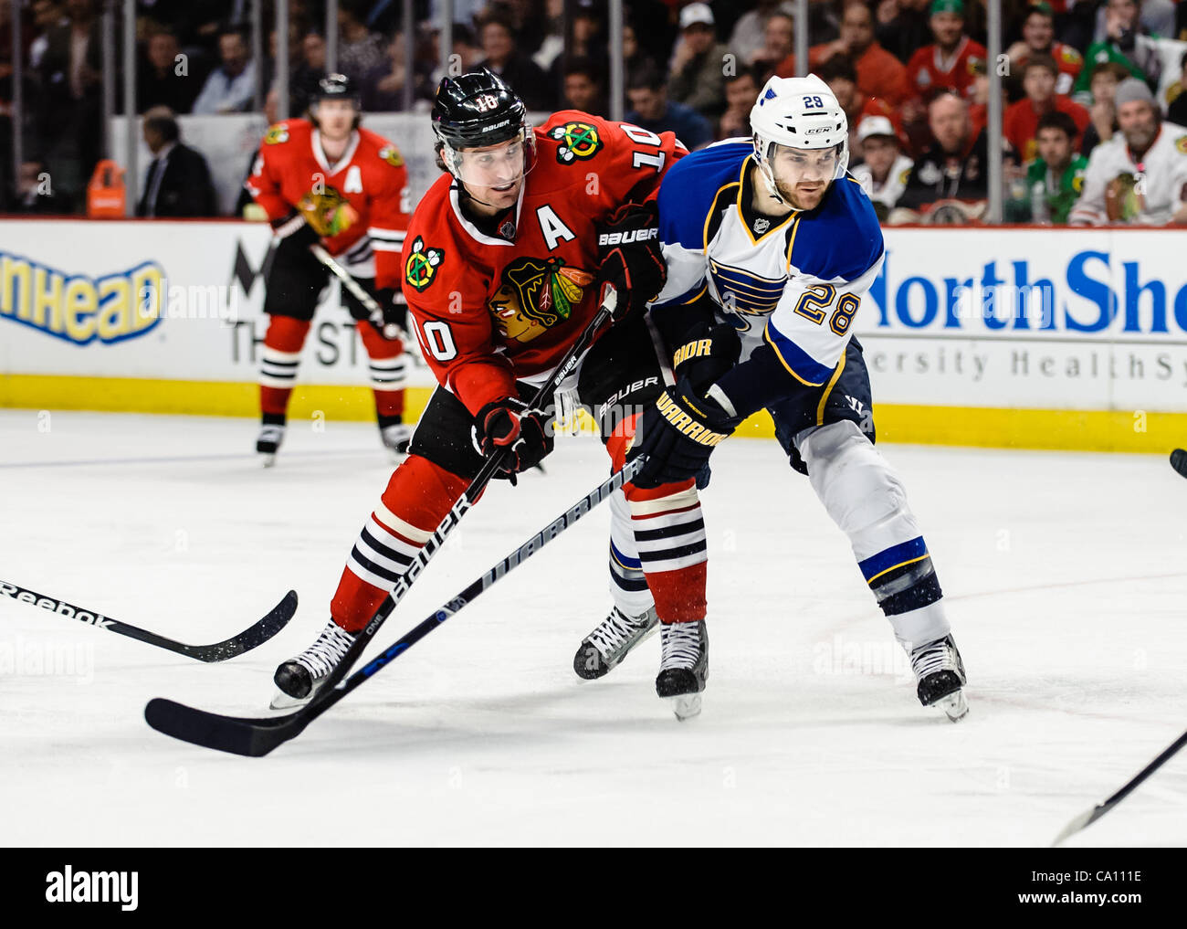 13. März 2012 - Flügel Chicago, Illinois, USA - Chicago links Patrick Sharp (10) kämpft für Position mit St. Louis Verteidiger Carlo Colaiacovo (28) während des NHL-Spiels zwischen den Chicago Blackhawks und den St. Louis Blues im United Center in Chicago, IL. Die Blackhawks besiegt den Blues 4-3 Stockfoto