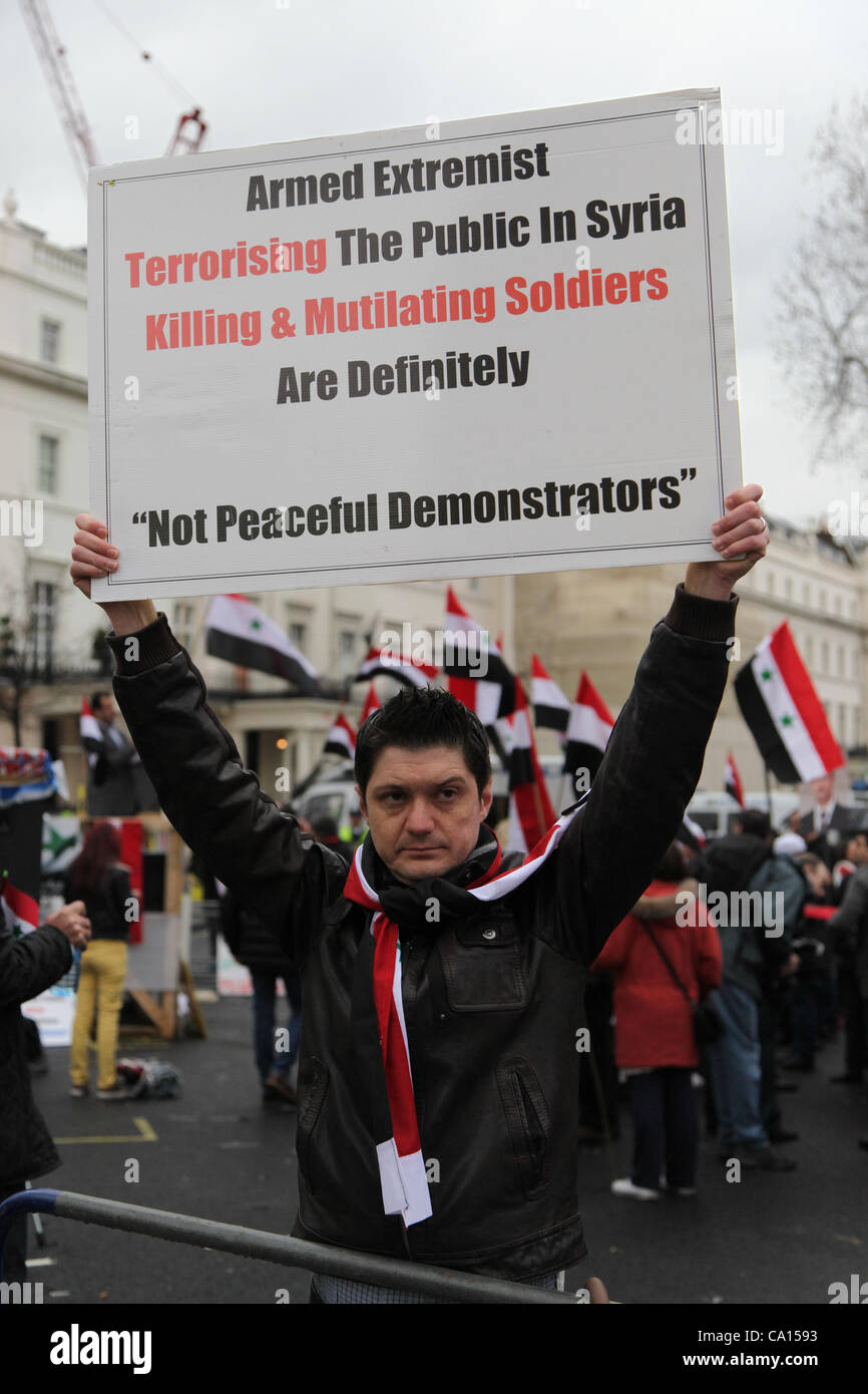 LONDON, UK, 17. März 2012. Ein Demonstrator des Pro-Assad-Regimes hält ein Plakat, das besagt, dass die Anti-Assad in Syrien "Nicht friedliche Demonstranten" sind. Pro und Anti-Assad Demonstranten versammelten sich vor der syrischen Botschaft in London. Stockfoto