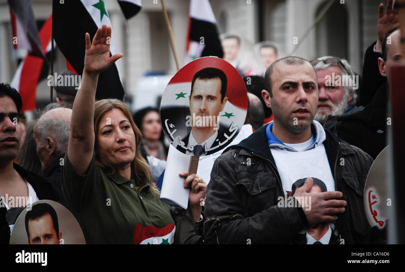 17.03.2012, London, UK: Pro-Assad Demonstranten singen der Nationalhymne am Ende ihrer Kundgebung vor der syrischen Botschaft in London, winken Bilder von Assad. Stockfoto