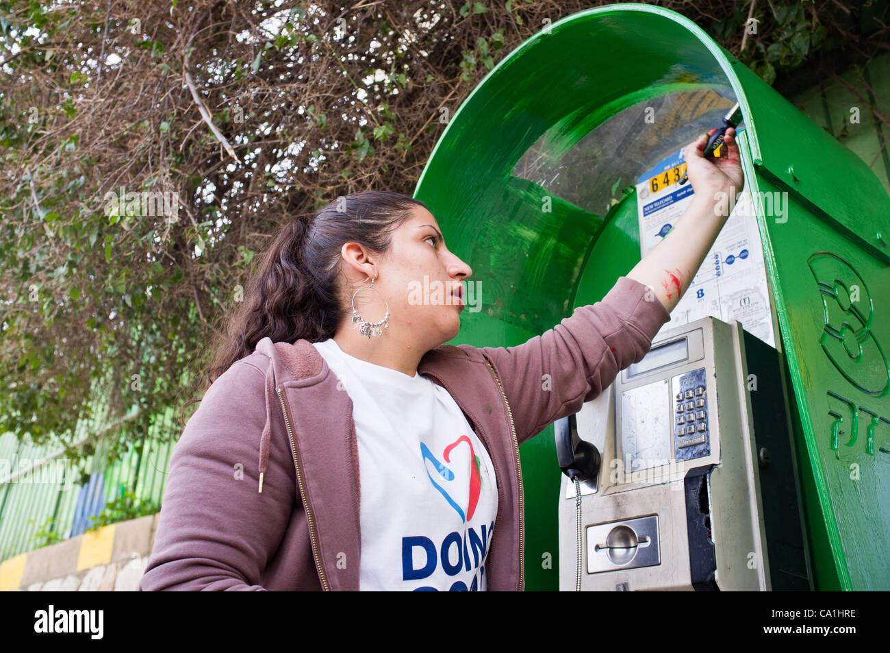 Ein junger Student malt eine öffentliche Telefonzelle in einem 48 Projekte durchgeführt, in der Stadt, mit einer Rekordzahl von 6.000 Freiwilligen am"guten Taten" in ein nationales Projekt, das Arbeit für die Gemeinschaft fördert. Jerusalem, Israel. 20. März 2012. Stockfoto