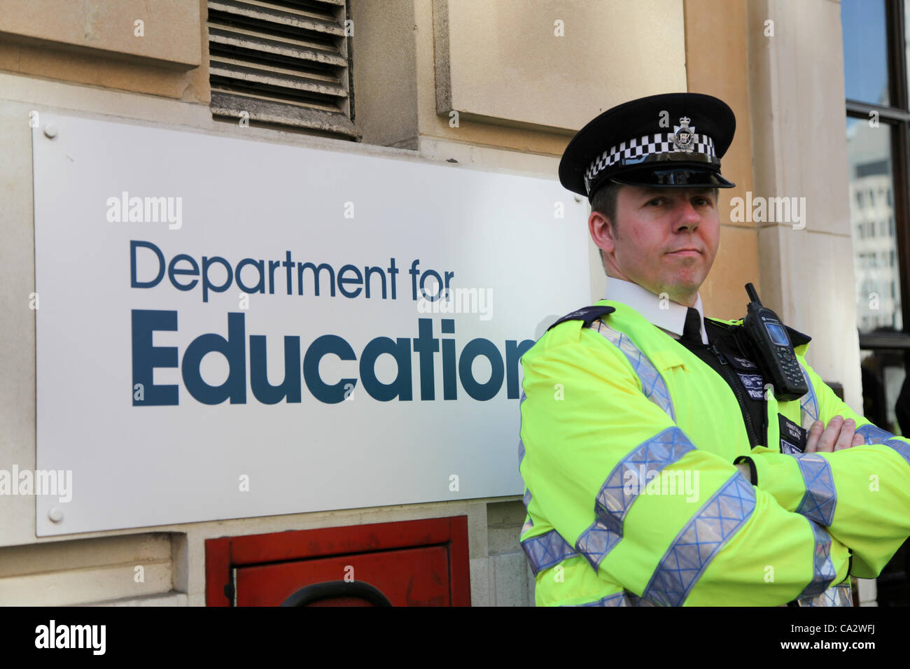 LONDON, UK, 28. März 2012. Ein Polizist steht Wache außerhalb des Department of Education, die Mutter März vergeht. Tausende von Dozentinnen und Dozenten versammelten sich in Malet Street vor dem Marsch nach Westminster zum protest gegen die Pläne der Regierung für die öffentlichen Renten. Stockfoto