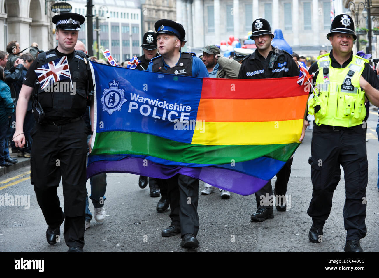 Warwickshire Polizisten mit einem schwulen Regenbogen Flagge marschieren, Rechte der Homosexuellen in Birmingham Stolz Karnevalsumzug feiern Stockfoto