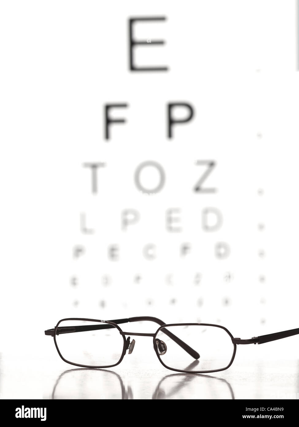 Gläser auf dem Tisch mit Auge-Test-Chart im Hintergrund, für ferne Vision testen Themen Stockfoto