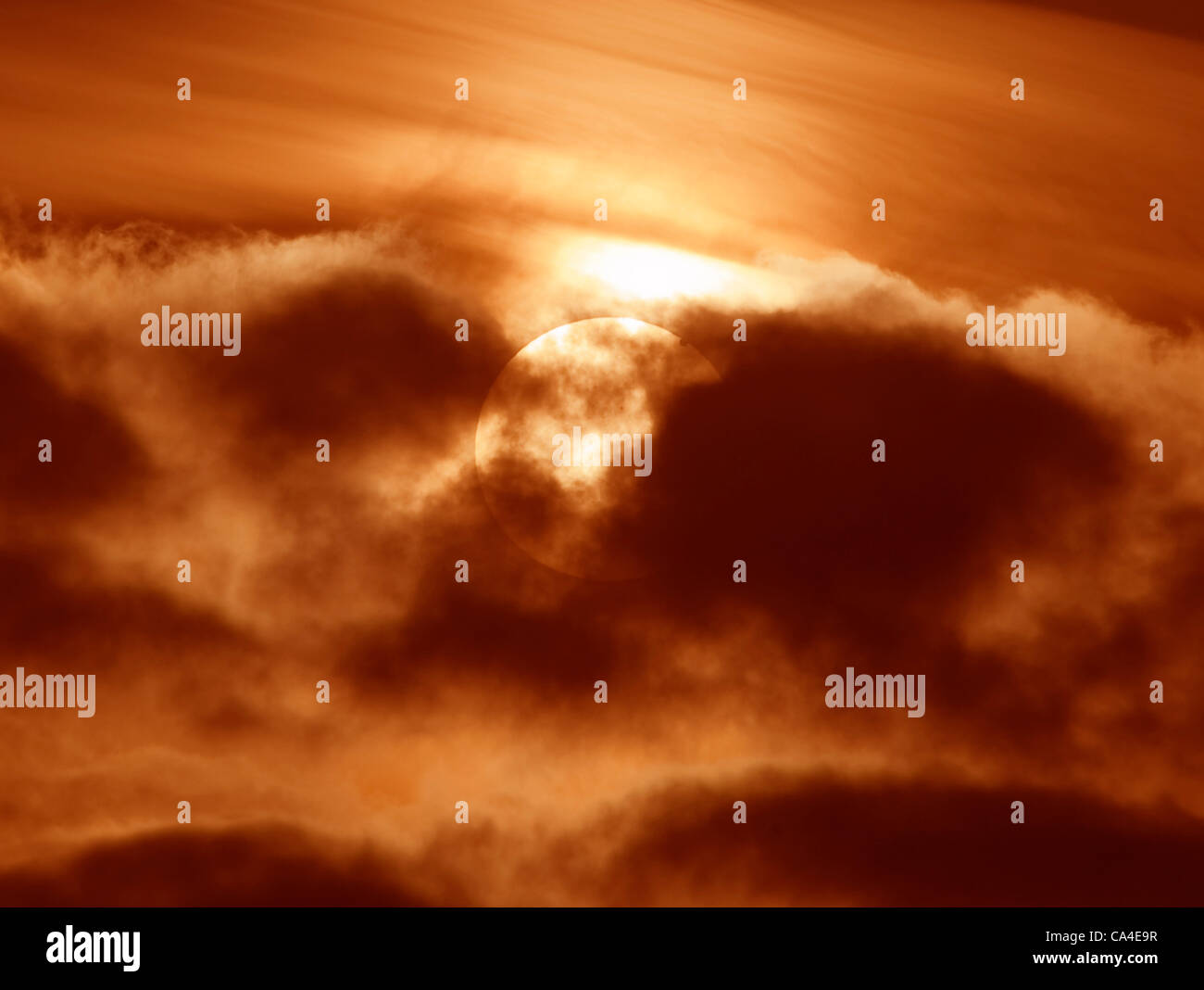 Ein seltene Venus-Transit der Sonne am 6. Juni 2012 fotografiert durch Wolke aus London, UK am 05:42, mit Sonnenflecken auch sichtbar in Richtung Mitte des Datenträgers. Venus ist rechts in der Nähe von Rand der Sonnenscheibe sichtbar oben. Stockfoto
