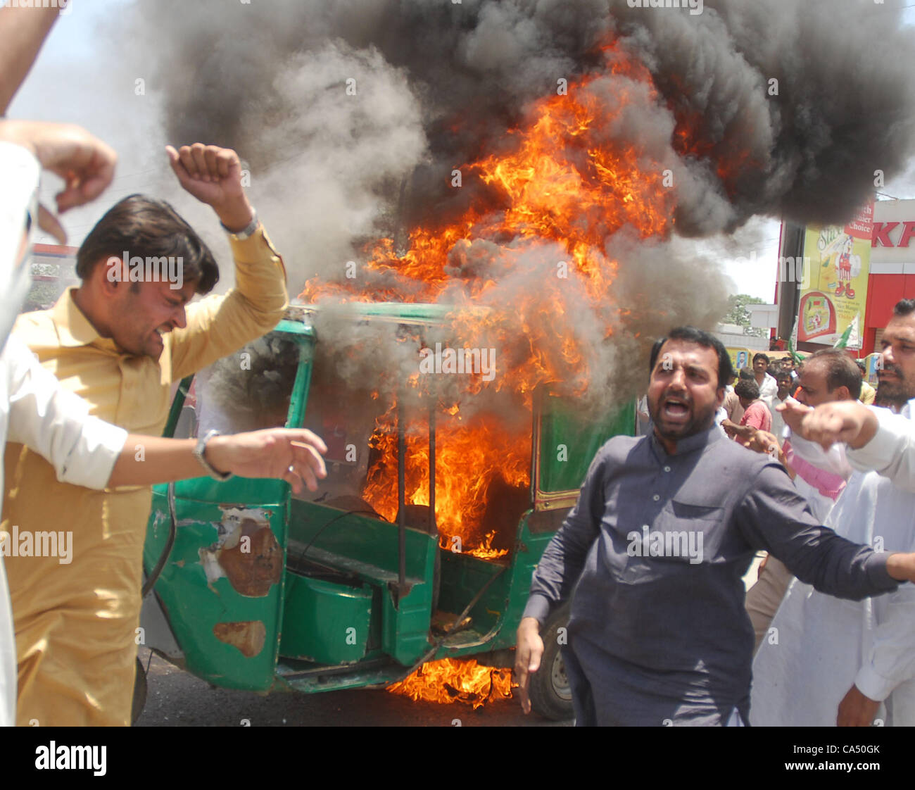 Ein Fahrer, seine Auto-Rikscha in Brand gesetzt, während einer Demonstration von allen Pakistan CNG Dealers Association am Tukhar Niaz Baig. Die Demonstranten kritisiert stark die mögliche Erhöhung der CNG-Tarife, während Parolen gegen die Regierung von ihnen bei der Gelegenheit in Lahore J skandierten waren Stockfoto