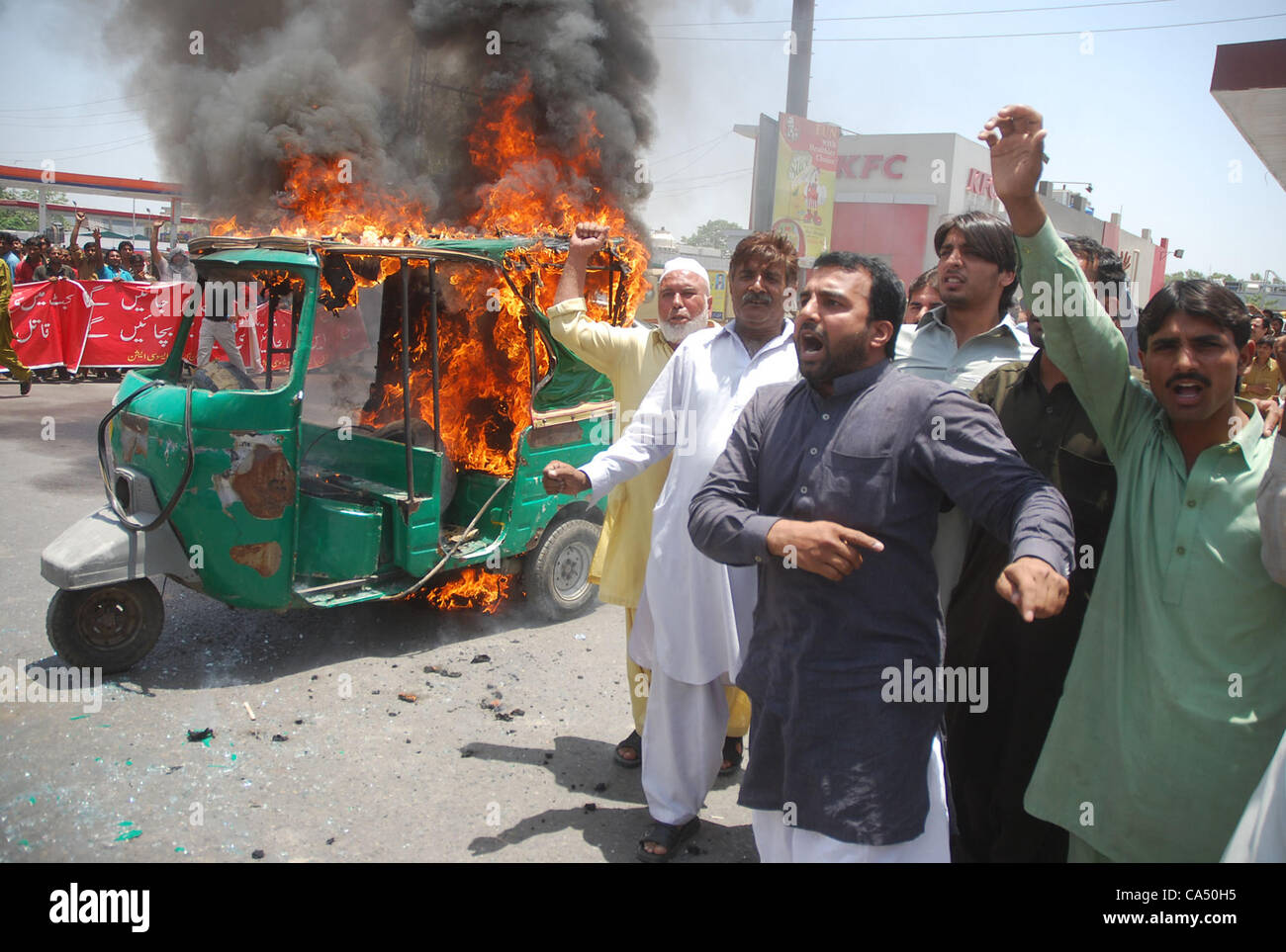 Ein Fahrer, seine Auto-Rikscha in Brand gesetzt, während einer Demonstration von allen Pakistan CNG Dealers Association am Tukhar Niaz Baig. Die Demonstranten kritisiert stark die mögliche Erhöhung der CNG-Tarife, während Parolen gegen die Regierung von ihnen bei der Gelegenheit in Lahore J skandierten waren Stockfoto