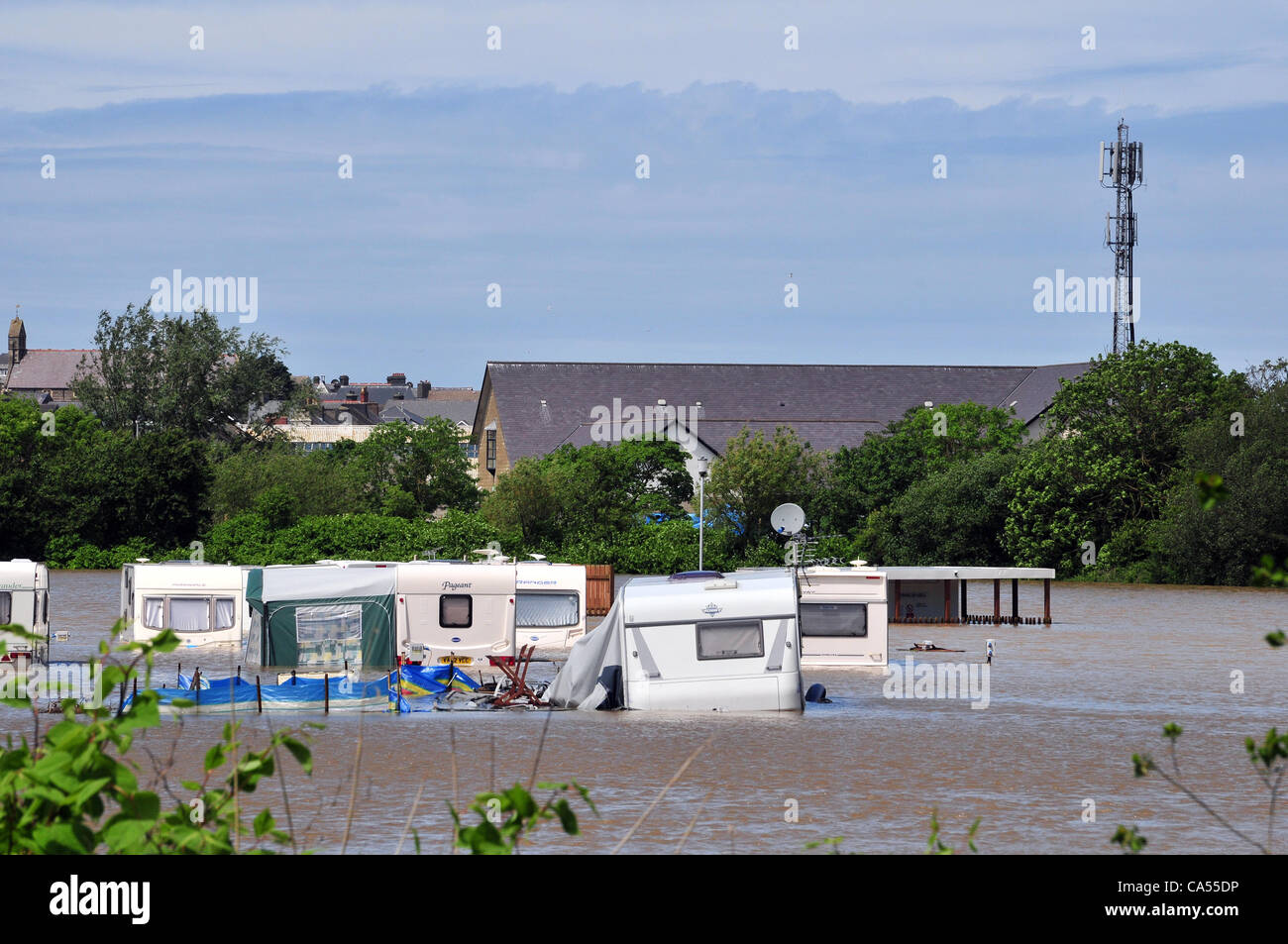 Samstag, 9. Juni 2012. Wohnwagen in einem Ferienpark am Ufer des Flusses Rheidol in Aberystwyth, West Wales, UK überflutet. Die Polizei-Station (mit Kommunikation Mast) im Hintergrund vermieden Überschwemmungen. Stockfoto