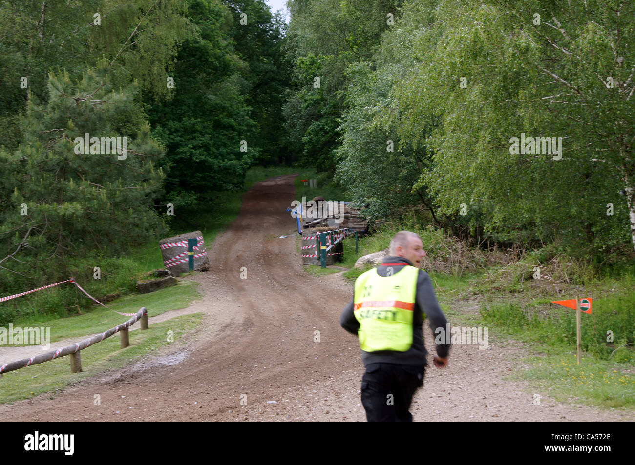 Sicherheit Marschall läuft der Peugeot 309, angetrieben von Nigel Hunt mit Andy Wright als Beifahrer die stürzte nach der Kollision mit einer Furche am Wald verfolgen vor 18 auf der Sherwood-Kiefern-Bühne. Stockfoto