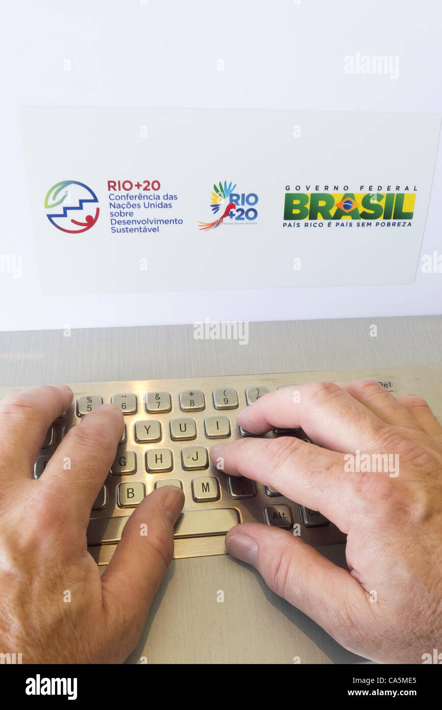 Ein Mann ist auf der Tastatur eines Computers spezielle Informationen mit einem Rio + 20-Aufkleber und Brasilien Irakkrieg Aufkleber eingeben. UN-Konferenz über nachhaltige Entwicklung (Rio + 20), Rio De Janeiro, Brasilien. Stockfoto