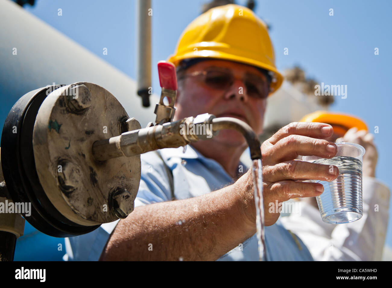 Abraham Tene, Vorsitzender des Wasser Entsalzung Verwaltung und Entsalzung Bereichsleiter bei der Wasserbehörde Israel trinkt entsalztes Meerwasser in Ashkelon Entsalzungsanlage produziert. Ashkelon, Israel. 13. Juni 2012. Stockfoto