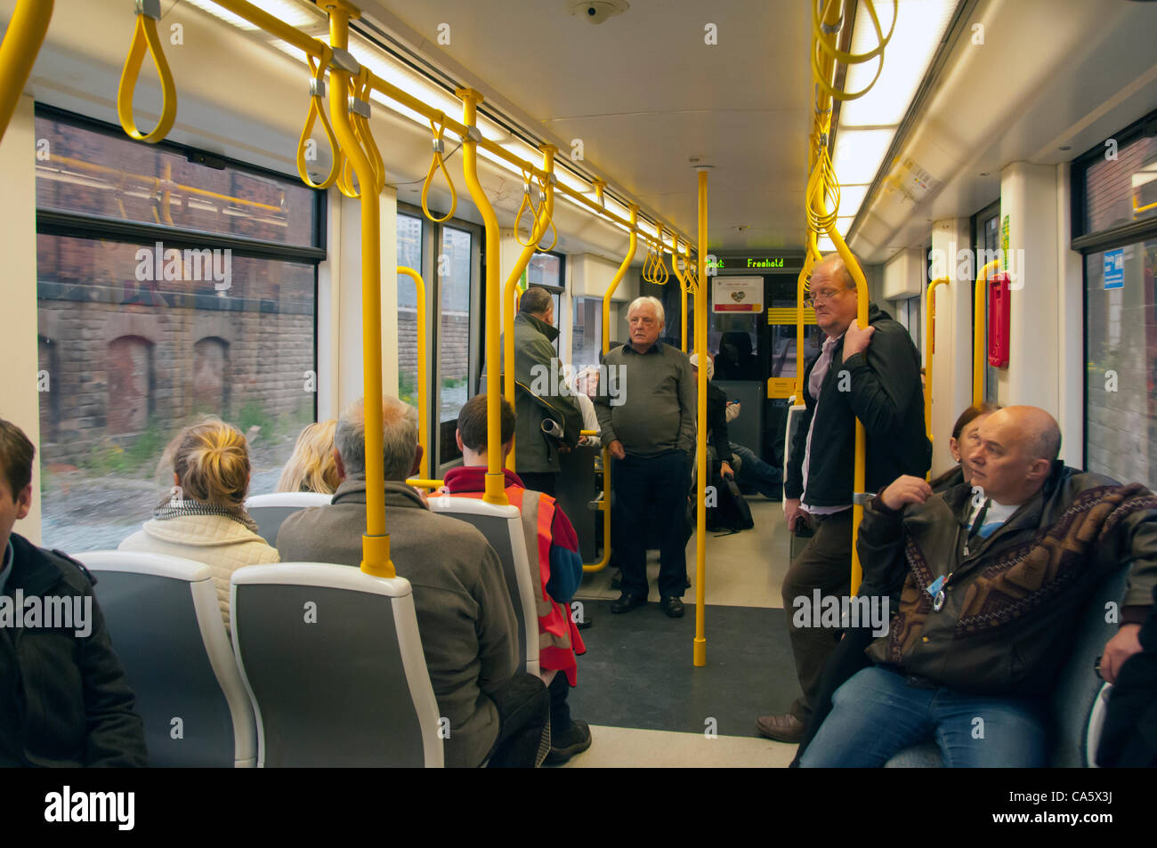 13. Juni 2012. Passagiere in einer Straßenbahn auf seiner Rückreise nach Manchester nach Abschluss der ersten Passagier Service auf die neue Metrolink Tram Service nach Oldham. Stockfoto