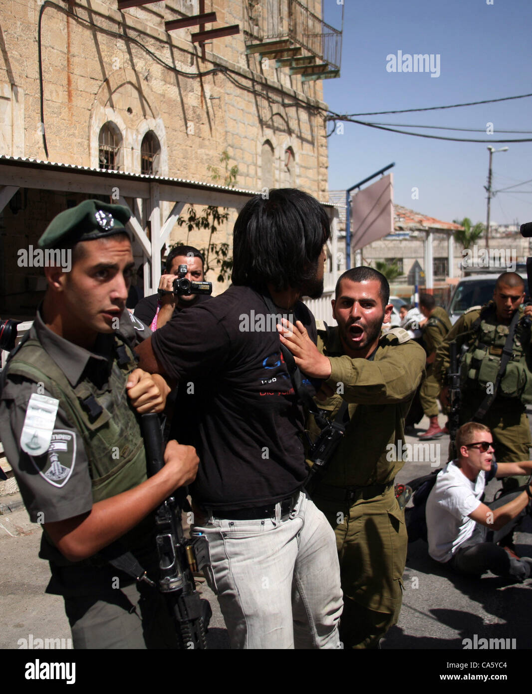 13. Juni 2012 - Hebron, Westjordanland - israelische Soldaten und Polizisten versuchen, einen Demonstrator während einer Protestaktion gegen die Schließung von der zentralen Straße Ulica al-Shuhada zu verhaften, die offen nur für die israelischen Siedler, die dort leben. (Kredit-Bild: © Mamoun Wazwazi/APA-Images/ZUMAPRESS.com) Stockfoto