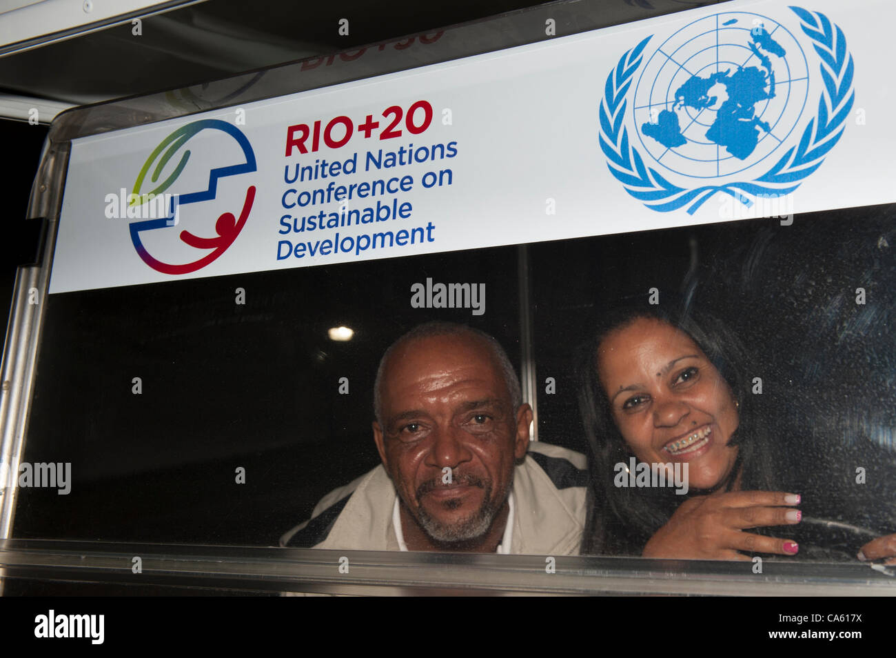 Zwei Brasilianer, ein Mann und eine Frau, lächelnd unter ein Zeichen für die Konferenz. UN-Konferenz über nachhaltige Entwicklung (Rio + 20), Rio De Janeiro, Brasilien, 13. Juni 2012. Foto © Sue Cunningham. Stockfoto