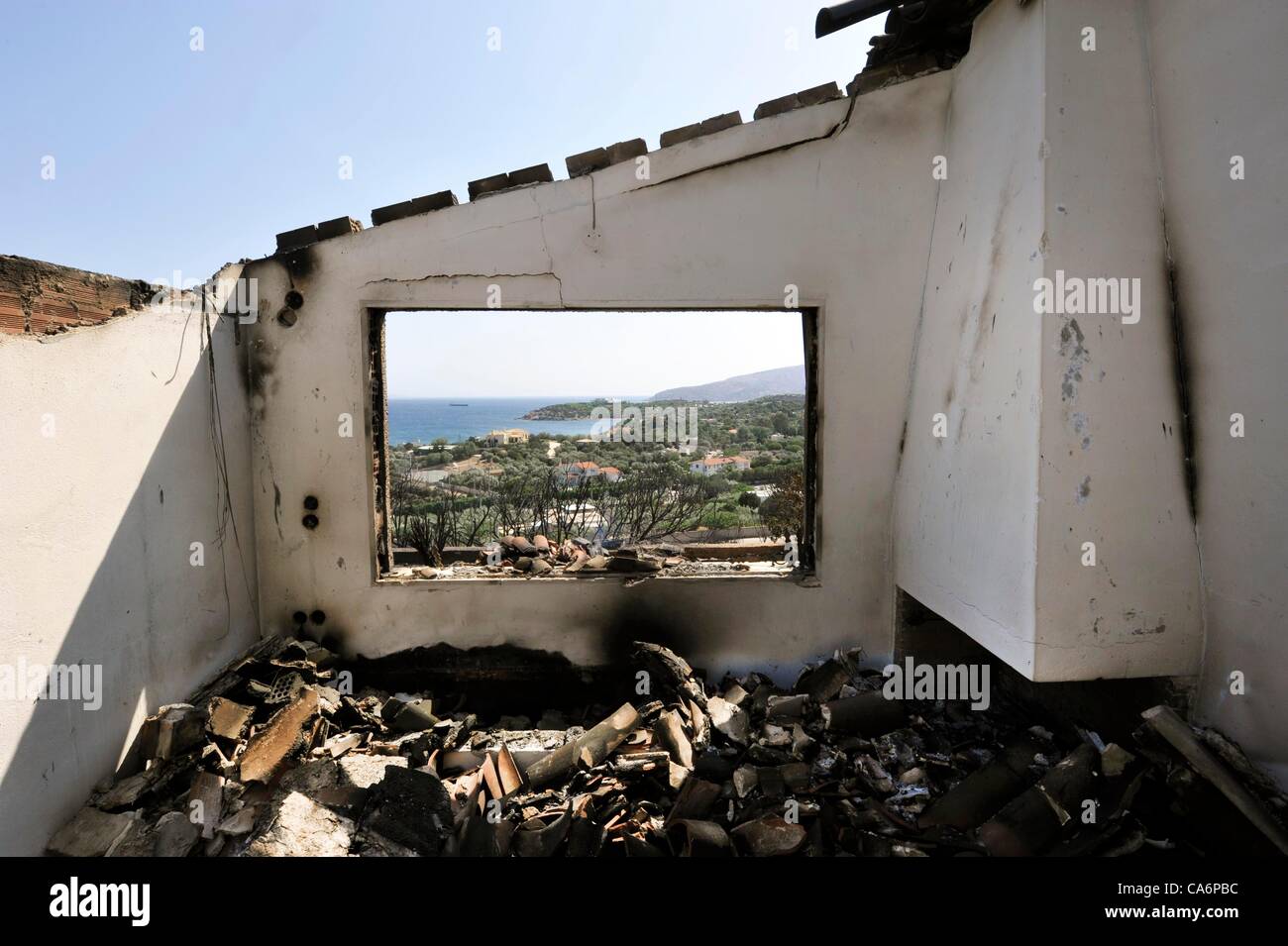 17. Juni 2012 Attika, Griechenland. Bewohner in Attika, südlich von Athen, mussten zusehen, wie Eigenschaften wie Feuer brannte, angefacht durch starke Winde und hohe Temperaturen über das Gebiet verteilt. Brände haben in mehreren Bereichen in Griechenland mit der Polizei Berichten Festnahmen wegen Fahrlässigkeit und Brandstiftung ausgebrochen. Stockfoto