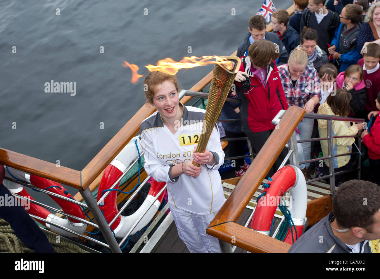 Stephanie Booth mit Olympischen Fackel auf dem Dampf Cruiser The Tern bei der Ankunft in Bowness auf Windermere er Olympische Feuer an der historischen Dampfschiff Tern an Waterhead Pier Bord bereisen zu Bowness auf Windermere.In eines der größten Spektakel, die jemals in den Lake District, die Flamme der See von hundert andere Schiffe eskortiert überquert. Olympischer Fackellauf Stockfoto