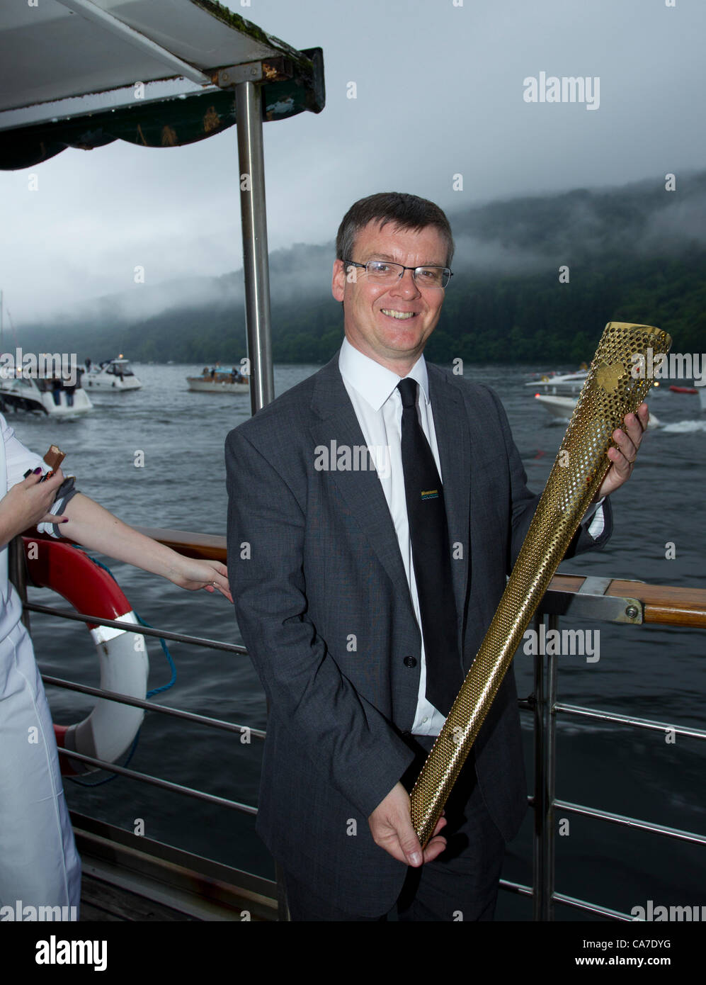 Nigel Wilkinson Managing Director Windermere Kreuzfahrten auf dem See mit Olympischen Fackel: Flamme kreuzt Windermere am Dampf Boot bestieg er Olympische Flamme der historischen Dampf Boot Tern Olympischer Fackellauf Stockfoto