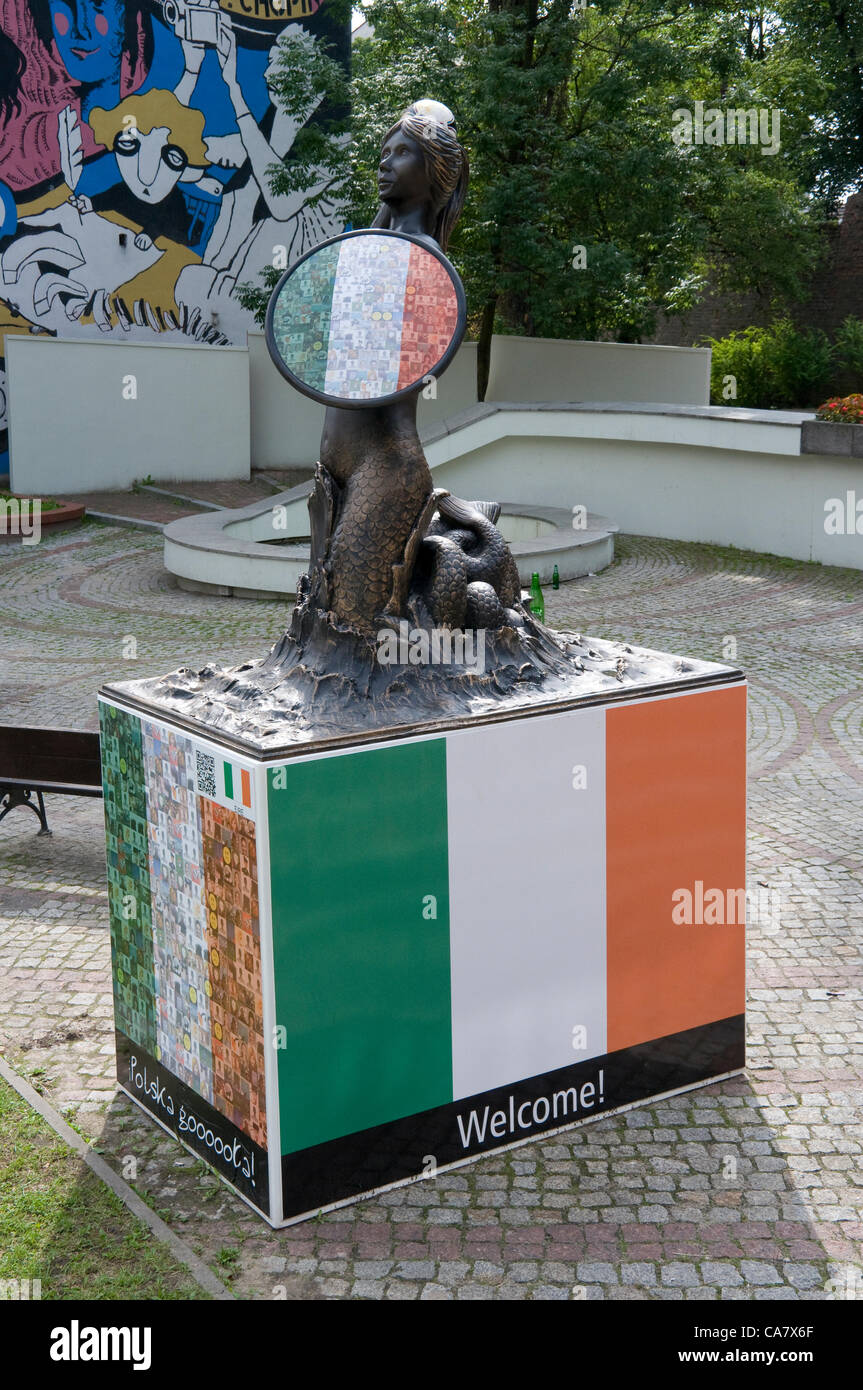 Statue der Meerjungfrau (Symbol Warschaus) irische Flagge steht in Warschau während der Europameisterschaft 2012. 16 Monumente, Wahrzeichen der Stadt wurden in Warschau, Fußball-Fans aus ganz Europa begrüßen zu dürfen. 23. Juni 2012 Stockfoto
