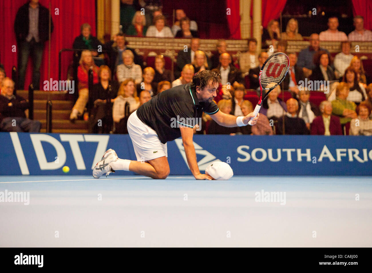 01.12.2011. London, England. Henri Leconte (FRA) taucht auf dem Boden während der Aktion gegen Pat Cash (AUS) am dritten Tag des Spiels an die Aegon Masters Tennis in der Royal Albert Hall Stockfoto