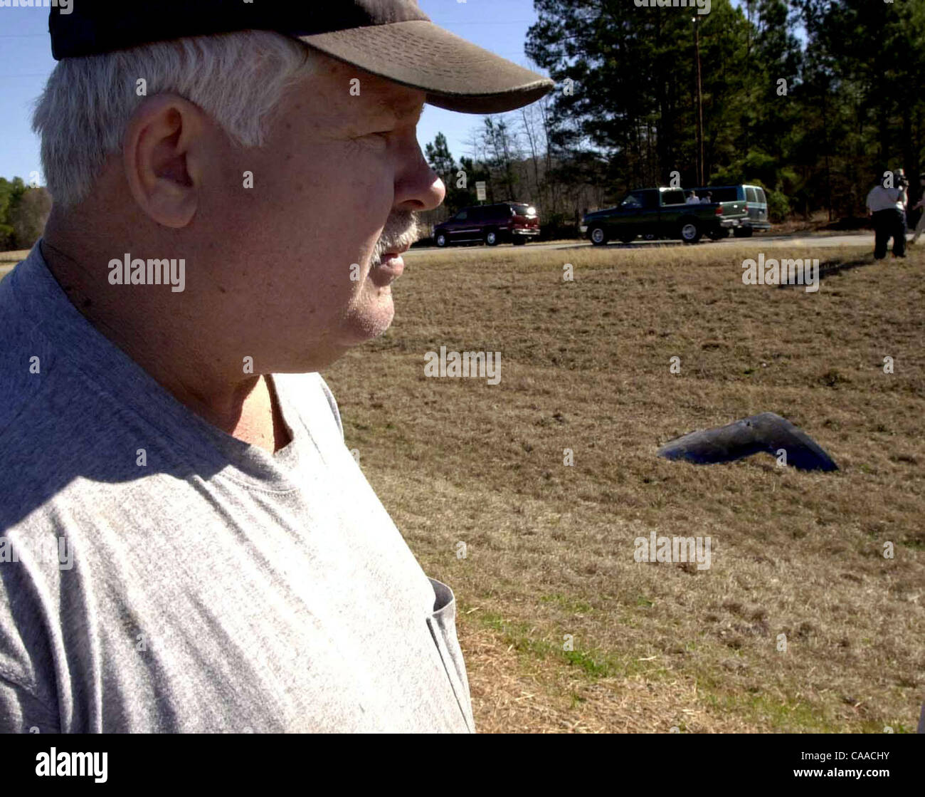 1. Februar 2003; Palästina, Texas, USA;  ! OHNE uns MAGS bis 04.02.2003! SCOTT WALKER Leiter der Elmwood VFD, schaut ein Stück Metall, das vom Himmel fiel am frühen Samstag Morgen auf Highway 155 nördlich von Palästina. Er und andere sagte, dass es immer noch das Rauchen als sie ankamen. Es wurde angenommen, dass pa Stockfoto