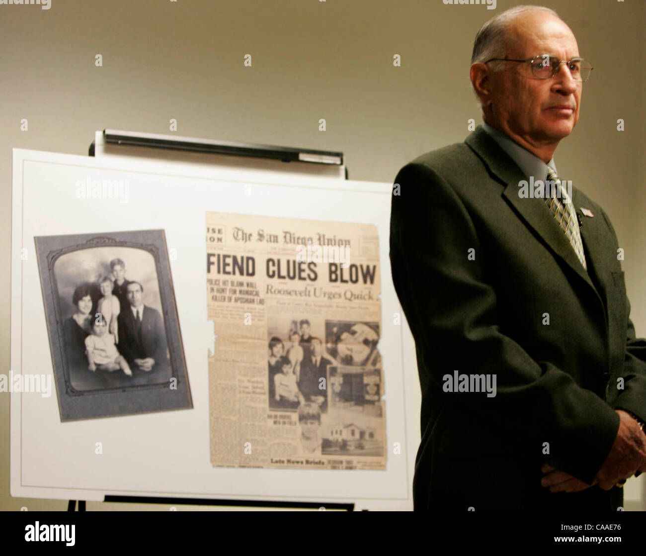 Während der Pressekonferenz zu verkünden ein 1933 Mord eines 7 Jahre alten Jungen zu lösen das Opfer Bruder Van (Cq) Aposhian (Cq) Mission Viejo (früher von Carlsbad) beantwortete Fragen aus den Medien. Hinter ihm ist ein Familienfoto und San Diego Union Titelseite. Im Jahr 1933 wurde die gesamte Stadt Angst Stockfoto