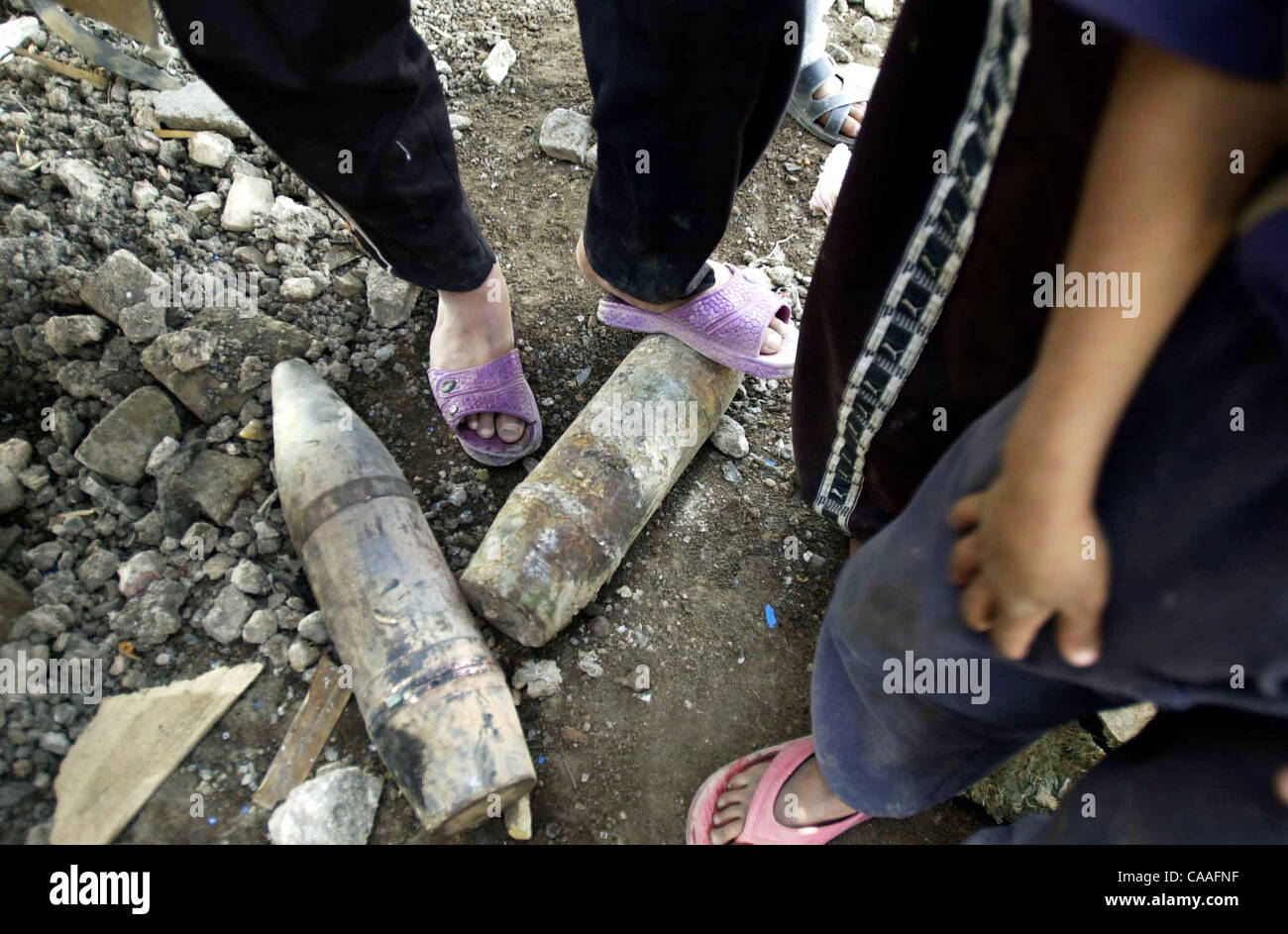(Veröffentlicht 21.04.2003, a-4): NC Bagdad X006... 18. April 2003, Bagdad, Irak... Verlassene Munition von der irakischen Armee zurückgelassen wird wo viele Kinder von Saddam City in ein offenes Feld spielen, viele Kinder oft abrufen Munition als Grenze Marke verwendet werden soll Stockfoto