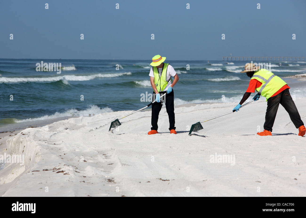 28. Juli 2010 hit - Pensacola, Florida, USA - Oil Spill Cleanup Besatzungen den weißen Sand von Pensacola Beach am Mittwochmorgen Rechen im Sand und Sichtung für Tar Balls. Wellen von klebrigen Teer Blobs wurden an Land zunehmend auf dem weißen Sand von der Florida Panhandle letzte Woche als Slicks her waschen Stockfoto