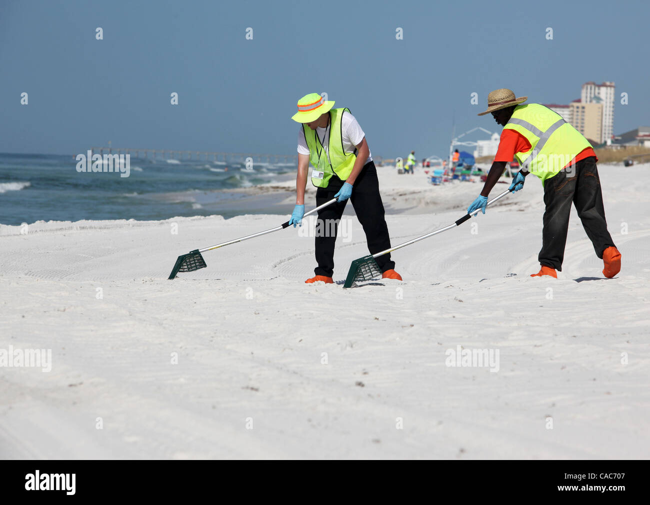 28. Juli 2010 hit - Pensacola, Florida, USA - Oil Spill Cleanup Besatzungen den weißen Sand von Pensacola Beach am Mittwochmorgen Rechen im Sand und Sichtung für Tar Balls. Wellen von klebrigen Teer Blobs wurden an Land zunehmend auf dem weißen Sand von der Florida Panhandle letzte Woche als Slicks her waschen Stockfoto