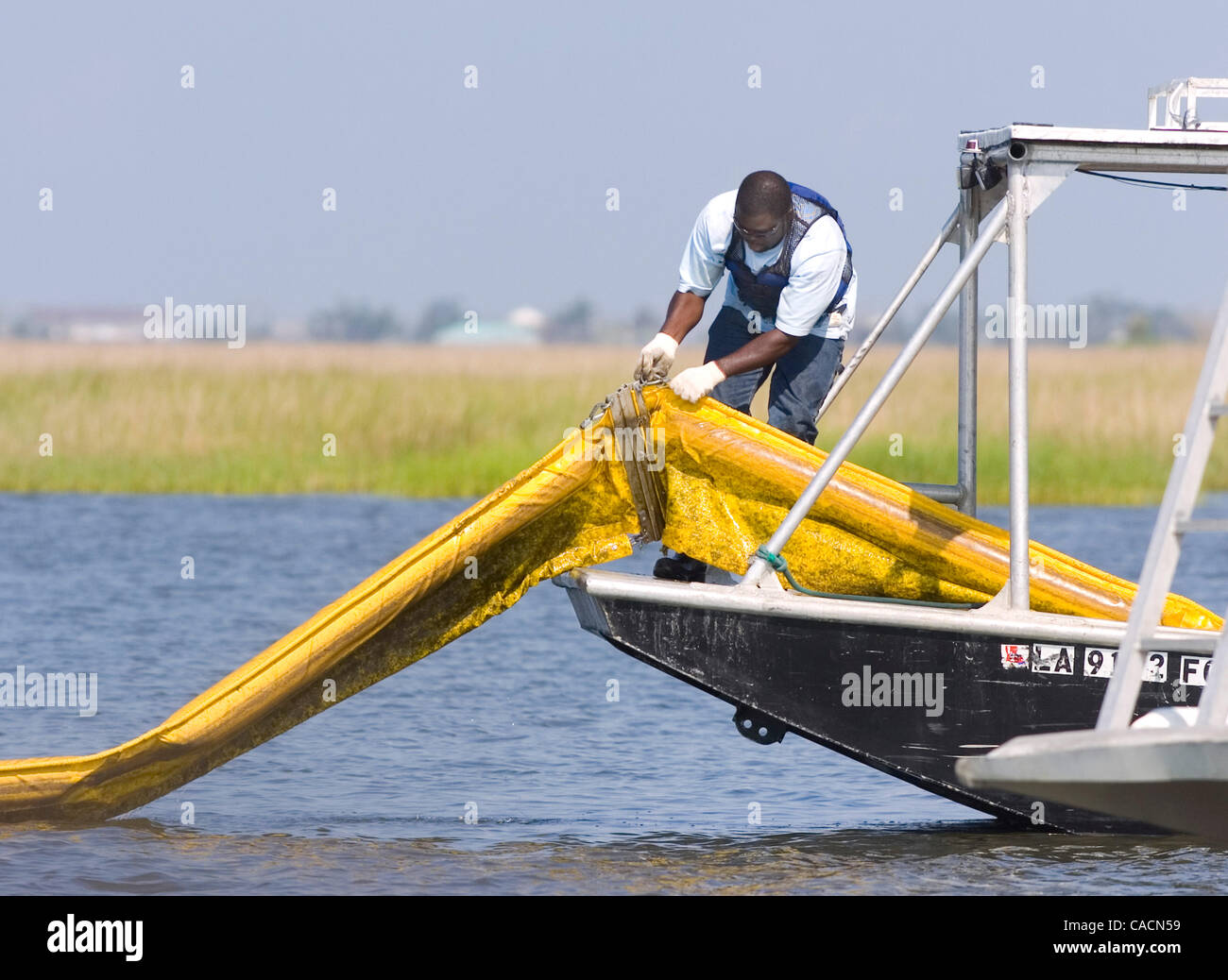 21. Juni 2010 - Cocodrie, LOUISIANA, USA - passt ein Zeitarbeiter Boom Sumpfgras Terrebonne Bay in der Nähe von Cocodrie, Louisiana, USA, 21. Juni 2010 zu schützen. Die BP Deepwater Horizon Oil Spill, der vor zwei Monaten begonnen hat, ist die größte in der Geschichte der USA und weiterhin bedrohen Wildtiere, die EG Stockfoto
