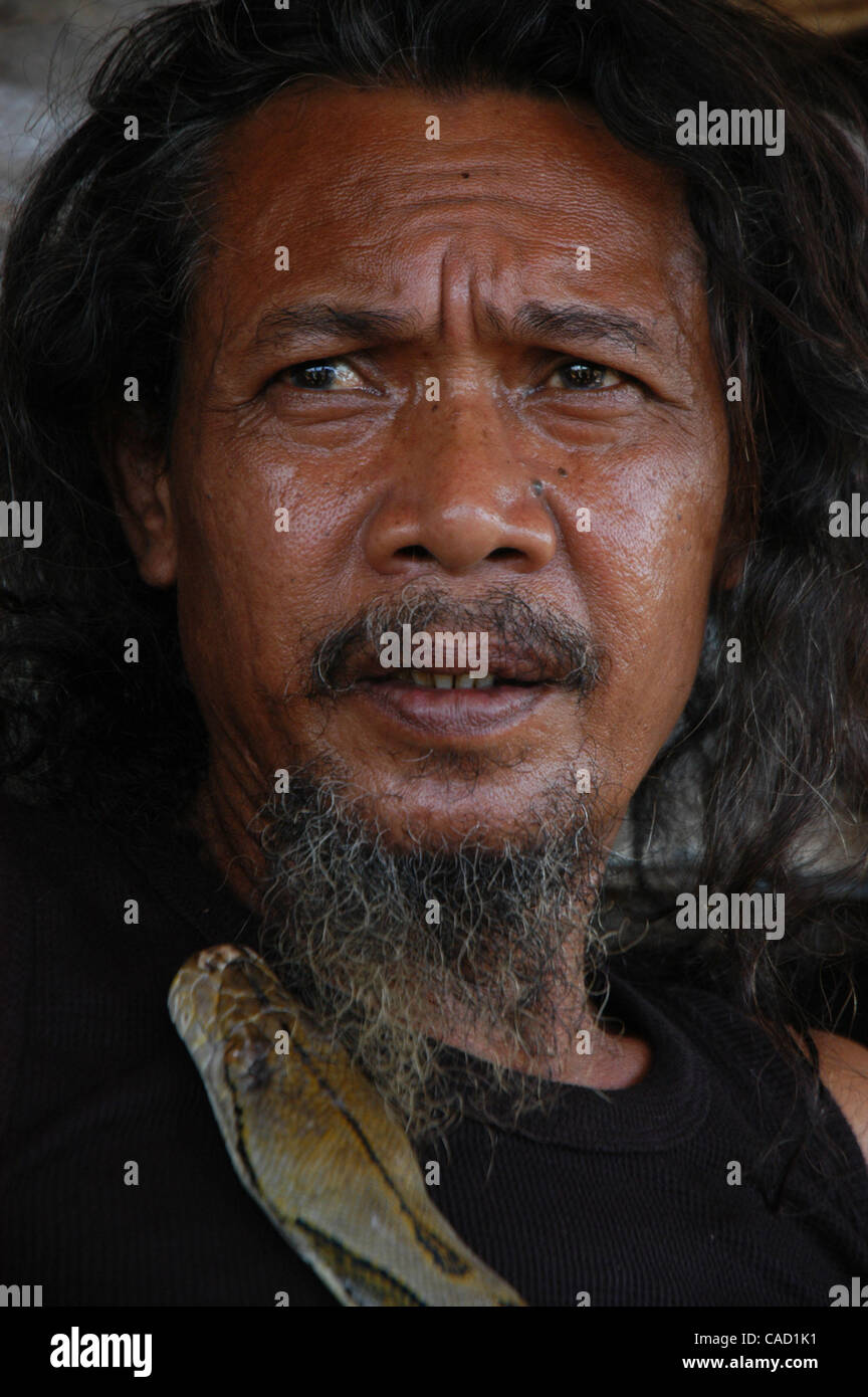 Ein Tier-Handler, spielt BIDUT mit seinem Lieblings-Python in Jakarta, 31. Juli 2010. Der 62 Jahre alte traditionelle Medizinpraktiker verwendet Reptil, Froschteile und Kräuter in seinem Elixiere, die er angeblich HIV/AIDS zusammen mit einer Reihe von anderen Erkrankungen heilen kann. Stockfoto