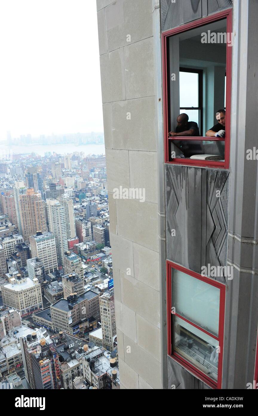 14. Juli 2010 - Manhattan, New York, USA - Ricky Anderson und Jose Accantara ein Fenster im 61. Stock neu installieren. Das Empire State Building ist in dem Bemühen um das Gebäude nachweisbar grüne aller seiner 6.514 Doppel-hung, Dual-Fenster Fenster, 26.056 Glasscheiben insgesamt renoviert. Die bui Stockfoto