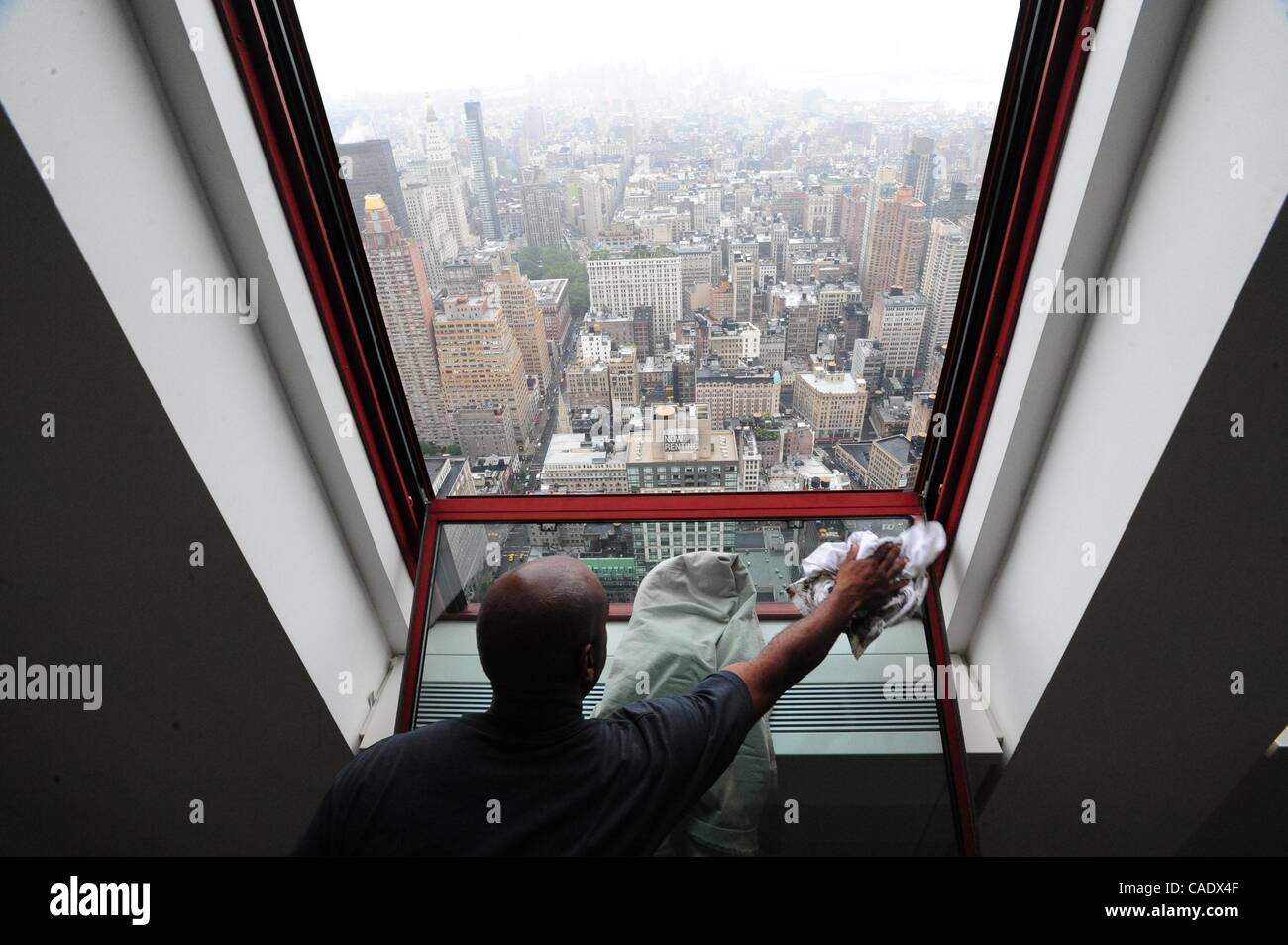 14. Juli 2010 reinigt - Manhattan, New York, USA - Ricky Anderson eine renovierte Fenster im 61. Stock. Das Empire State Building ist in dem Bemühen um das Gebäude nachweisbar grüne aller seiner 6.514 Doppel-hung, Dual-Fenster Fenster, 26.056 Glasscheiben insgesamt renoviert. Das Gebäude ist s Stockfoto