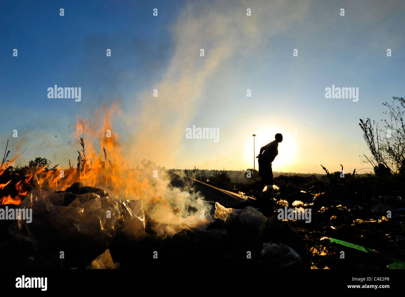 6. Juni 2010 - Johannesburg, Gauteng, Südafrika - Frauen brennen Müll in einem Feld in der Nähe von Orlando-Bahnhof Sonntag, 6. Juni 2010 in Soweto Township von Johannesburg, Südafrika. Das Feld wird verwendet, von Anbietern, die waren zu verkaufen und Dienstleistungen und die Frauen, die den Müll zu verbrennen versuchen zu halten Stockfoto
