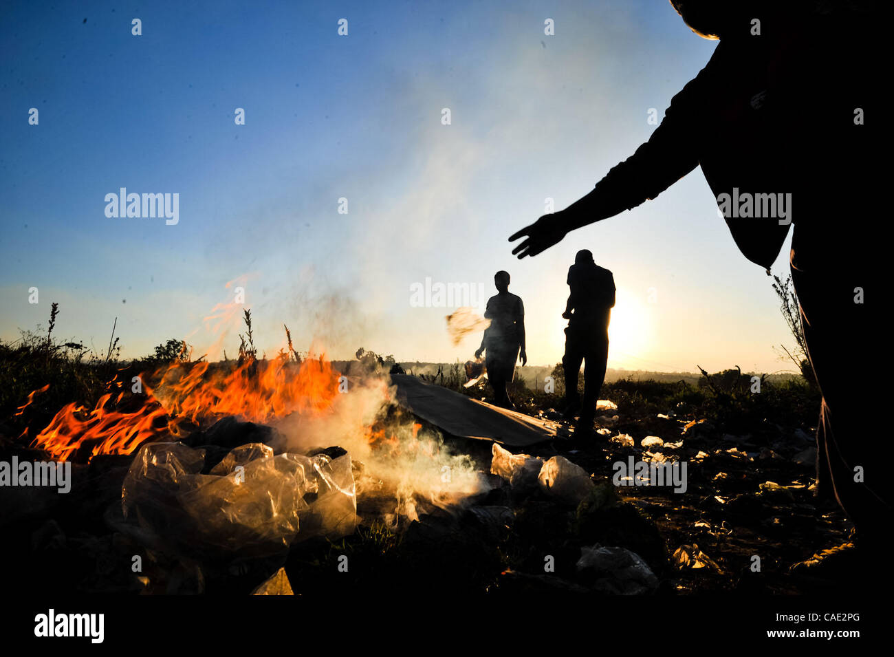 6. Juni 2010 - Johannesburg, Gauteng, Südafrika - Frauen brennen Müll in einem Feld in der Nähe von Orlando-Bahnhof Sonntag, 6. Juni 2010 in Soweto Township von Johannesburg, Südafrika. Das Feld wird verwendet, von Anbietern, die waren zu verkaufen und Dienstleistungen und die Frauen, die den Müll zu verbrennen versuchen zu halten Stockfoto