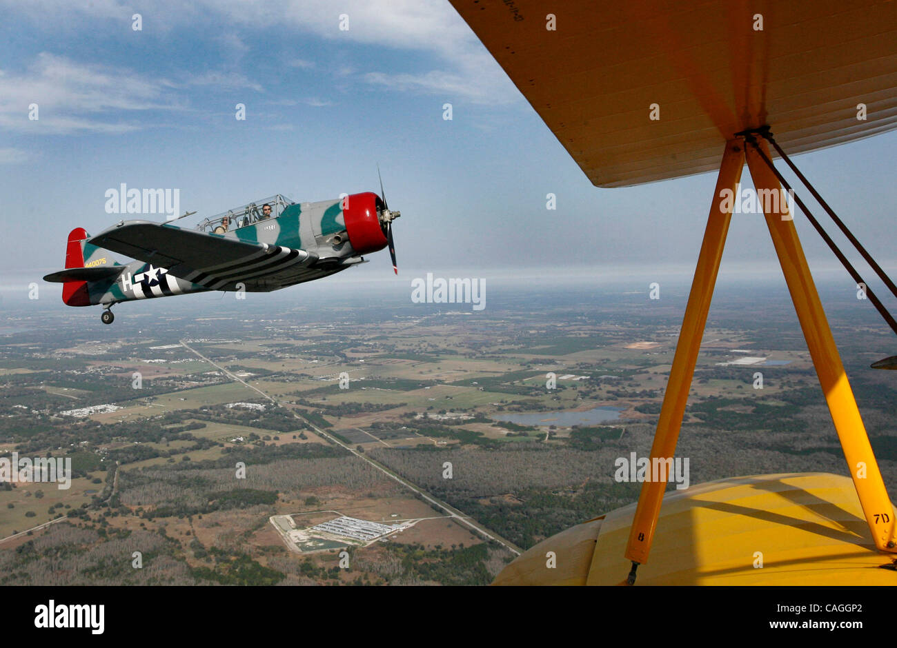 Aus der gelben Flügeln ein 1941 Stearman Doppeldecker, mal Personal Schriftsteller Chuin-Wei Yap kann gesehen werden, auf dem Beifahrersitz des Cockpits ein 1955 T-6 Texan als Pilot nimmt John Mackinson ihn für eine Kunstflug Achterbahnfahrt über Zephyrhills Freitagmorgen. Die Erfahrung ist Teil der 2008 Barnstormer Tour durch H Stockfoto