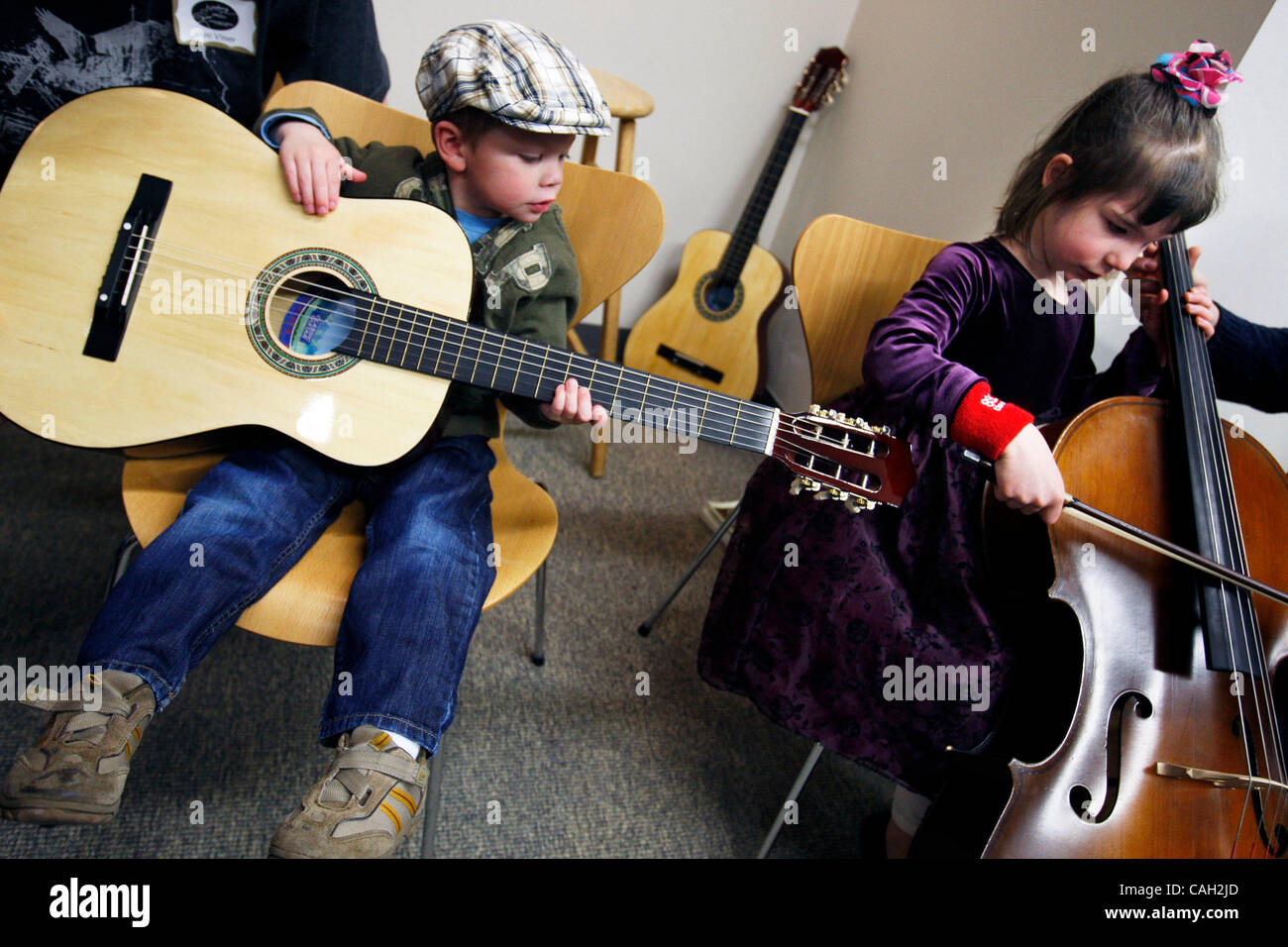 Minneapolis, MN; 27.01.07; von links nach rechts: am Rock die Wiege, Shea McKenney, 3, bekam, die Gitarre zu üben, während Sadie Willen, 5, bekam ihre Hände auf einem Cello während der Sitzung Instrument Streichelzoo wo Kinder waren in der Lage, die verschiedenen zur Verfügung stehenden Instrumente ausprobieren. (Kredit-Bild: © Minneapolis Star Tribune/ZUM Stockfoto