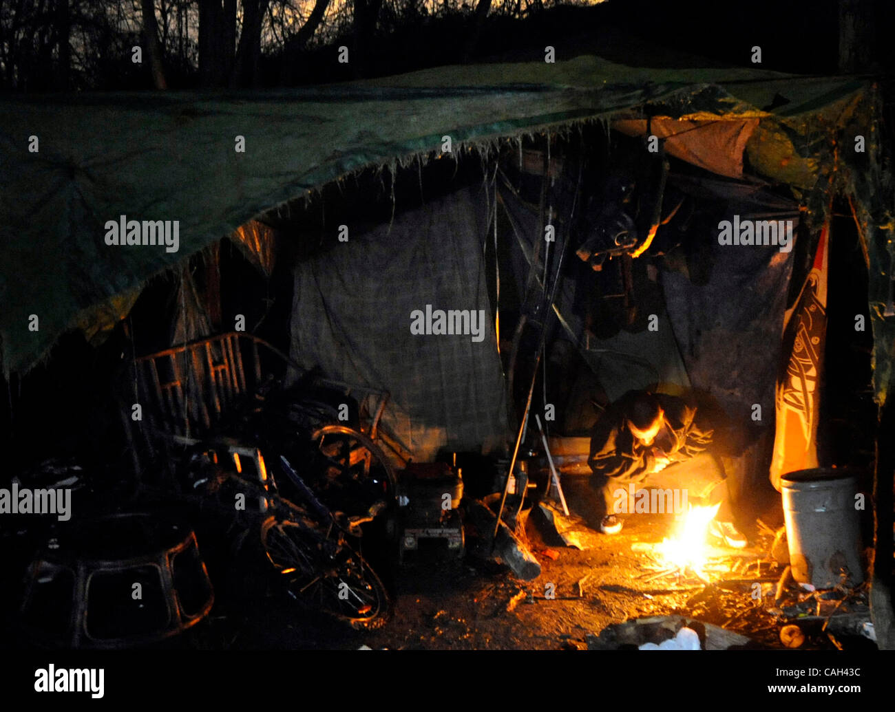 29. Januar 2008 - schürt Sacramento, Kalifornien, USA - ein Obdachloser, der unter dem Namen MIKE, oder Rock, sein Feuer in einem Multi-Zelt-Camp in der Nähe von Cal Expo Ende Dienstag, 29. Januar 2008 während einer Anzahl von ungeschützten Obdachlosen unter der Leitung von der Grafschaft Abteilung der menschlichen Hilfe. Als Voraussetzung für die Stockfoto