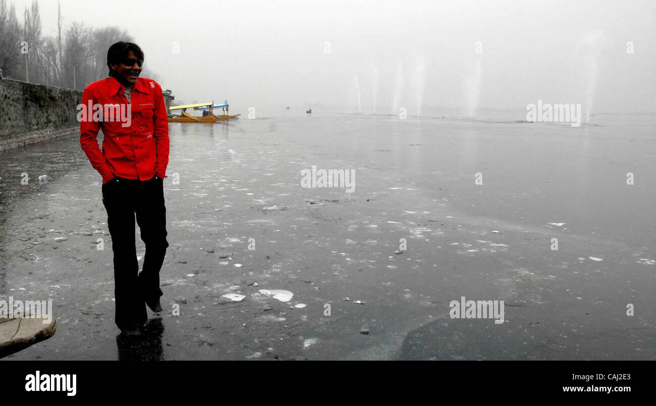 Ein Kaschmir muslimische Junge geht über den gefrorenen Rand der Dal Lake In Srinagar, der Sommerhauptstadt des indischen Kaschmir, Indien am 3. Januar 2008. Einen heftigen Kältewelle fegen Nordindien hat neun Menschen getötet, die Zahl der Todesopfer aus Wochen ungewöhnlich kalten Wetter auf 38, offizielle seit 01 Januar Stockfoto