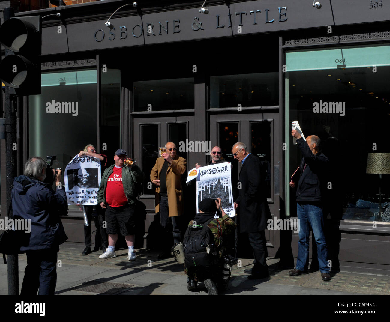 London, UK. 04.11.12. Anarchist, Ian Bone liefert Pasteten, Kanzler des Finanzministeriums, George Osbourne (Kurzwaren) Stoff und Tapeten-Shop auf der Kings Road in London. Der Snack-Attack-Protest ist gegen die Regierungen vorgeschlagenen pastöse Steuer- und Austery Maßnahmen. Stockfoto