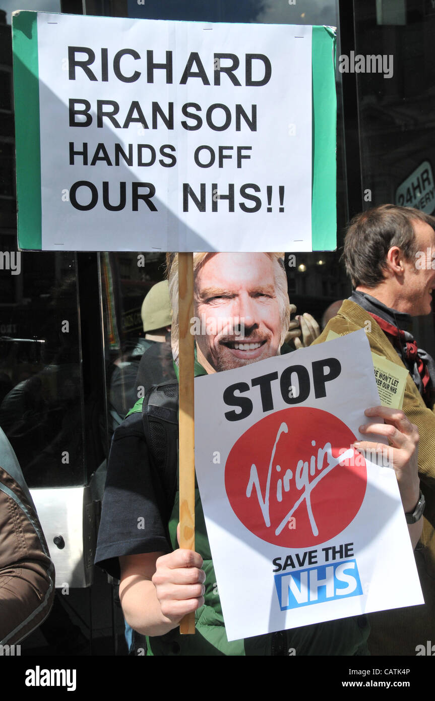 London, UK. Ein Demonstrant mit Richard Branson Maske außerhalb The Plaza, Gruppen Oxford Street, als Teil eines Protestes gegen die Jungfrau Beteiligung an NHS Gesundheitsfürsorge. 21. April 2012 Stockfoto