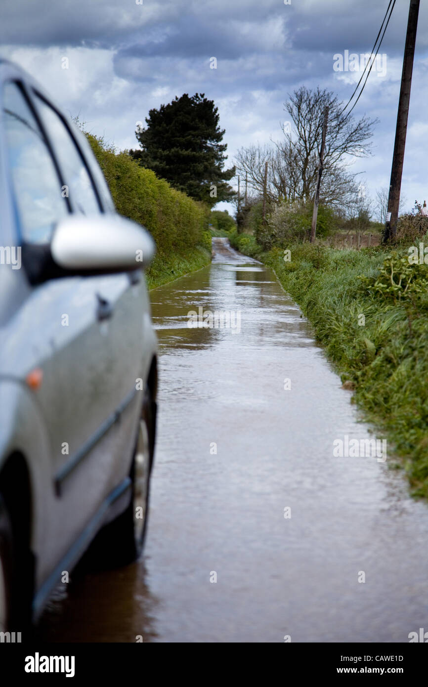 Starker Regen verursacht Überschwemmungen in North Norfolk, Großbritannien am Donnerstag 26. April 2012.A Auto durchläuft den Fluten auf einen Feldweg. Stockfoto