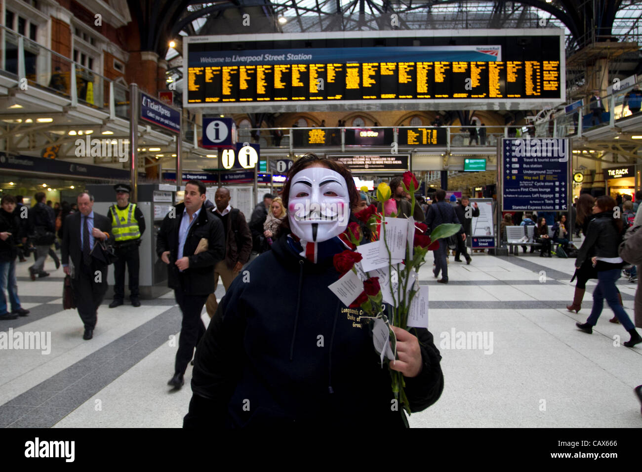 London, UK. 1. Mai 2012. Anhänger besetzt Liverpool Station zu besetzen. Demonstrant verschenkte Blumen Pendler anlässlich der internationalen Tag. Tag der internationalen Arbeiter (alias Maifeiertag) vereint Gewerkschafterinnen und Gewerkschafter, Arbeiter aus den vielen internationalen Gemeinschaften in London. Stockfoto